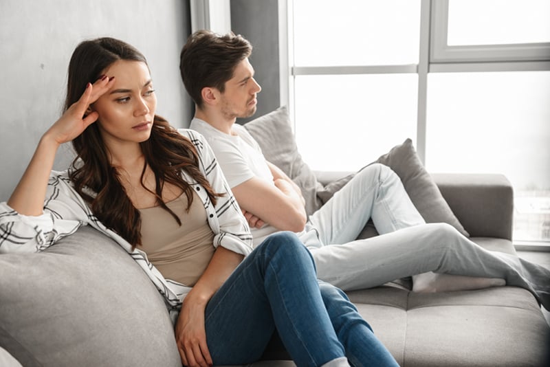 ein verärgertes Paar, das ohne Unterhaltung zusammen auf der Couch sitzt