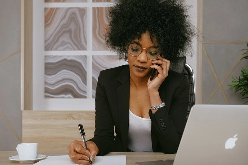 eine Frau, die einen Anruf hat, während sie in einem Büro bei der Arbeit sitzt
