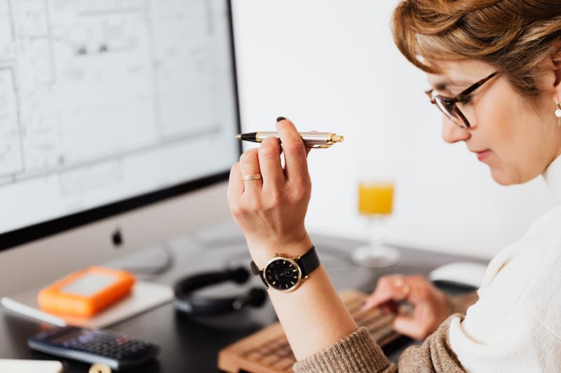 eine Frau, die einen Stift hält, während sie arbeitet und Geschäftsentscheidungen trifft