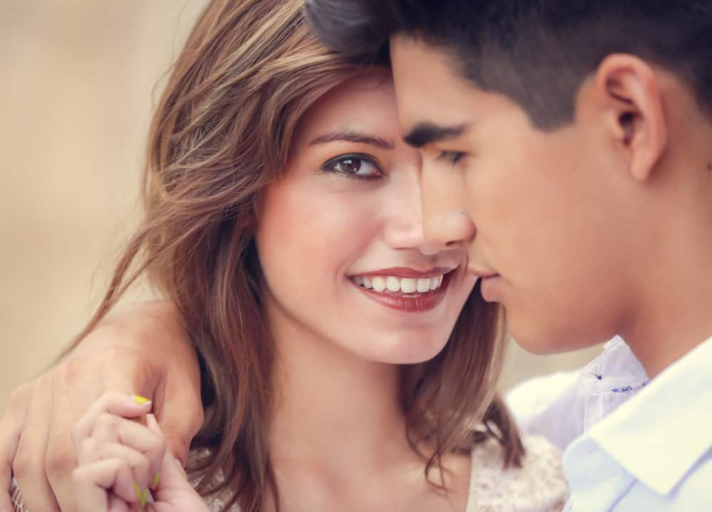 eine schöne lächelnde Frau in den Armen eines nachdenklichen Mannes