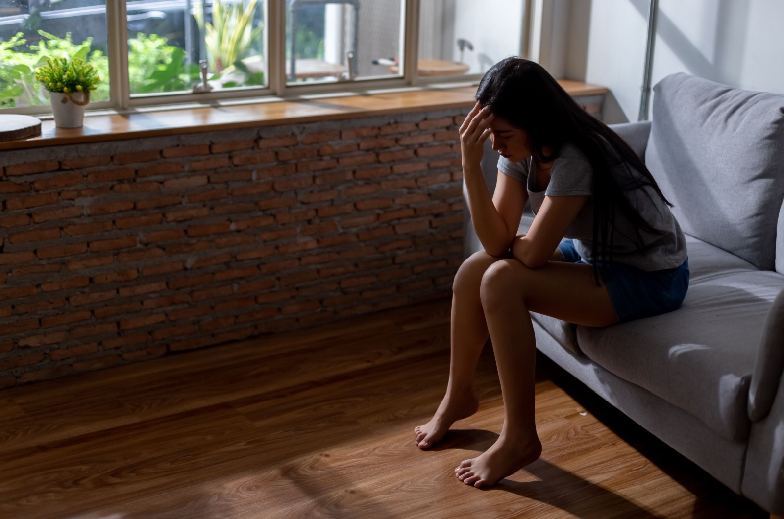 frau mit selbstzweifeln sitzt alleine