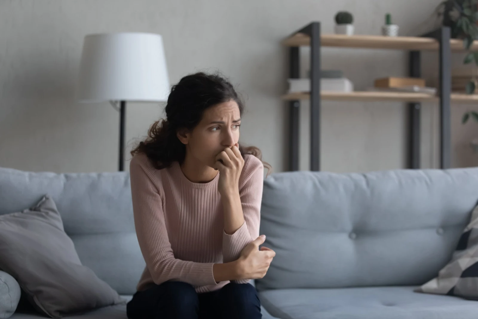 traurige Frau sitzt auf der Couch