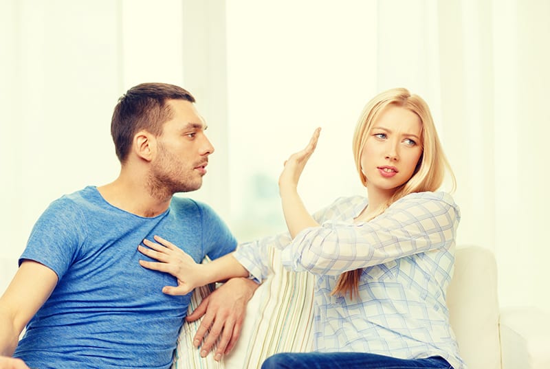 unglückliches Paar, das zu Hause einen Streit hat, während es auf dem Sofa sitzt