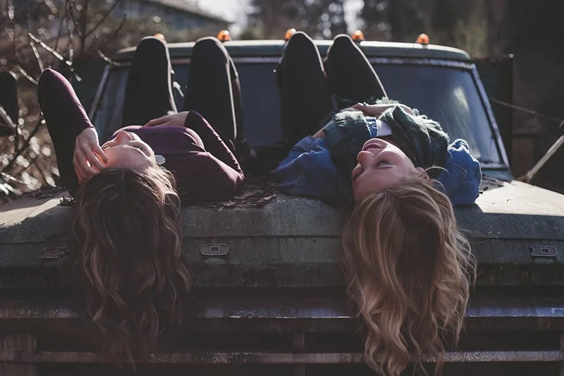 Zwei Frauen verbringen Zeit miteinander, während sie im Fahrzeug liegen