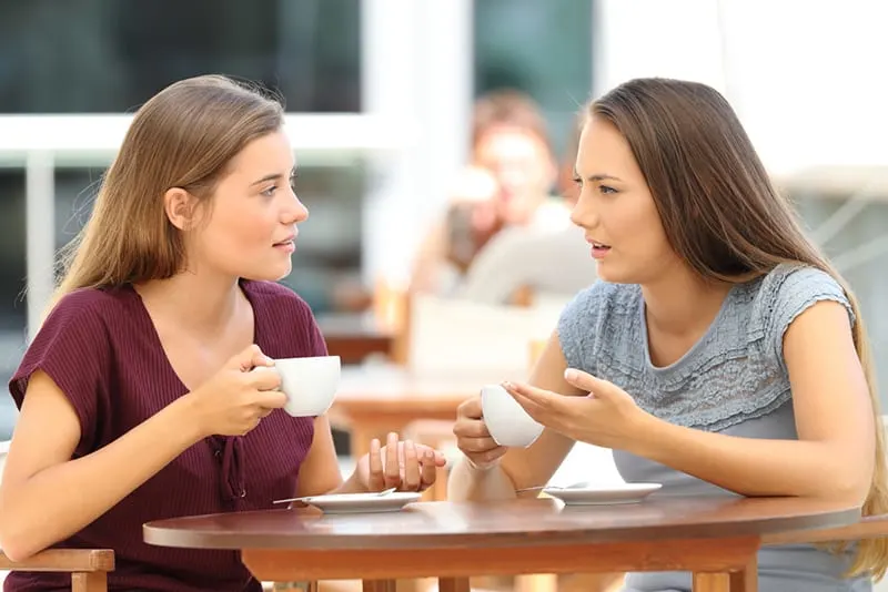 Zwei ernsthafte Freunde unterhalten sich beim Kaffeetrinken im Café