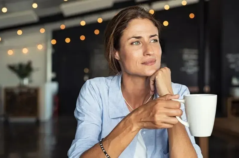 Achtsame Frau haelt eine Tasse