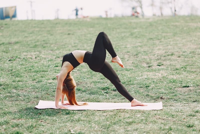Draußen praktiziert eine Frau Yoga