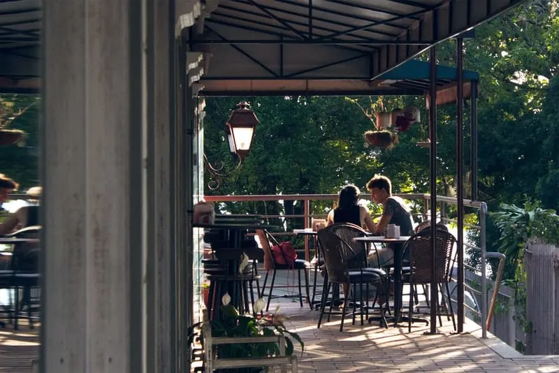 Ein Mädchen und ein junger Mann sitzen auf der Terrasse eines Cafés und unterhalten sich