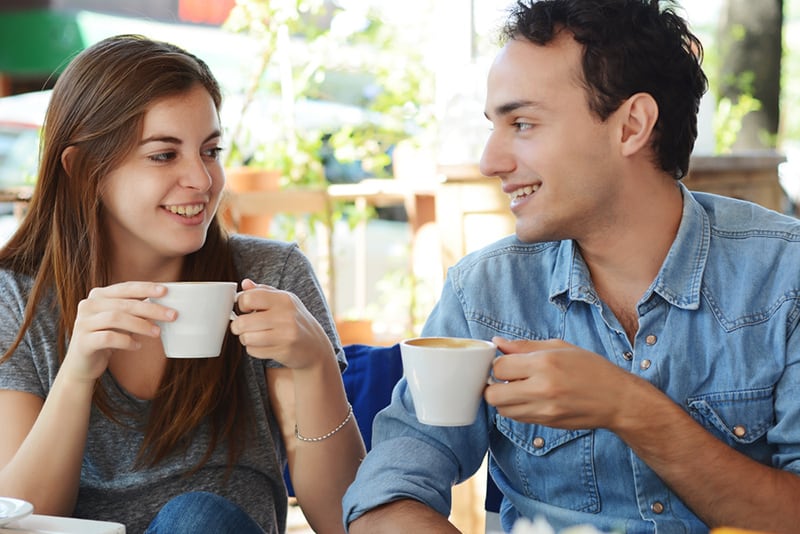 Ein Mann und eine Frau genießen einen Kaffee im Café und schauen sich an