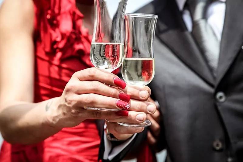 Ein Mann und eine Frau machen einen Toast mit einem Glas Champagner, während sie nahe beieinander stehen