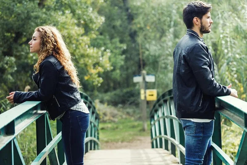 Ein Mann und eine Frau drehen sich wieder um, während sie auf der Brücke stehen