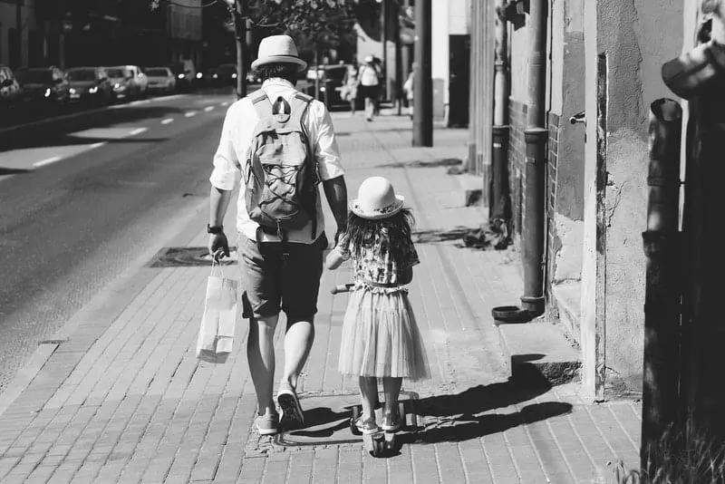 Ein Vater und eine Tochter gehen die Straße entlang