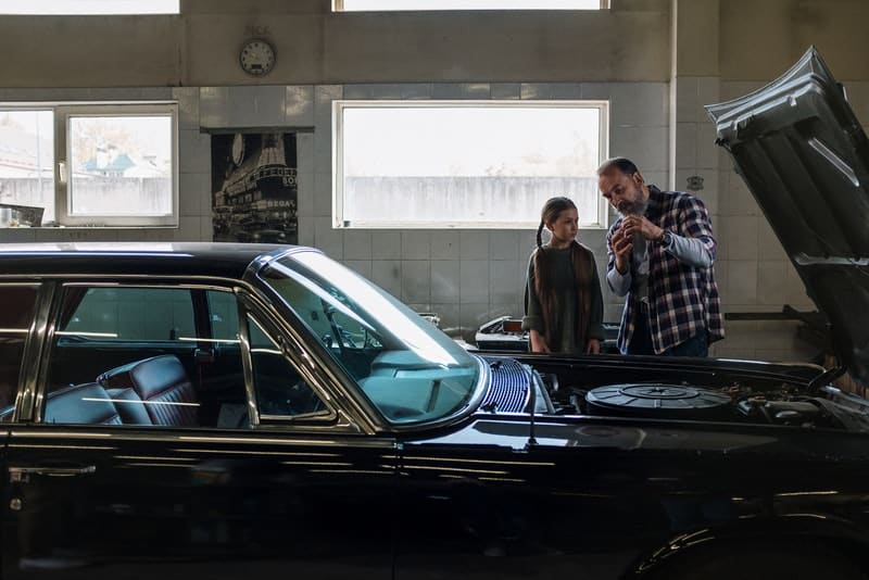 Ein Vater und eine Tochter in einer Garage reparieren ein Auto