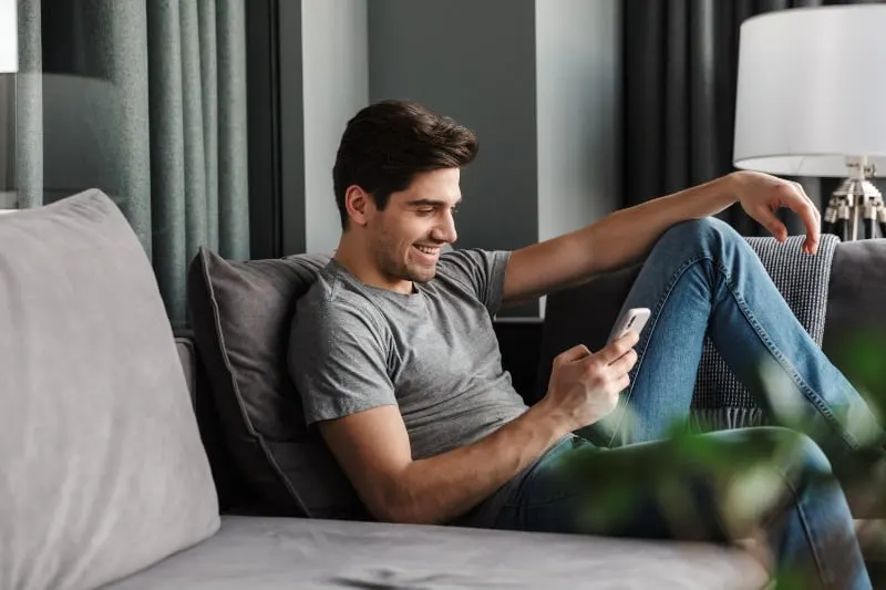 Ein attraktiver Mann mit Bart benutzt ein Handy