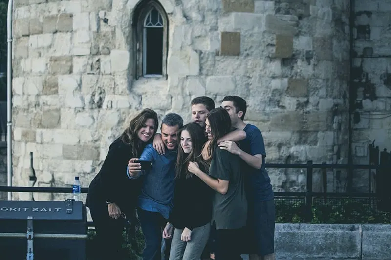Eine Gruppe von Freunden macht ein Selfie, während sie vor dem Gebäude stehen
