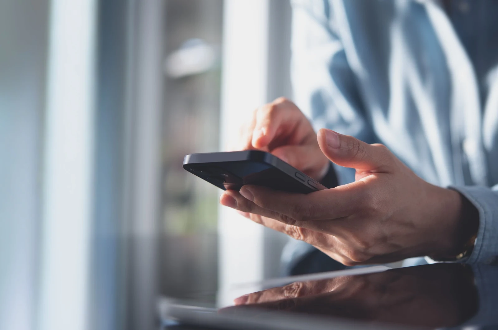 Frau tippt am Telefon