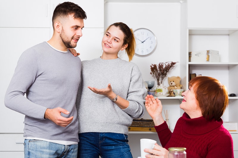 Glückliches Mädchen, das ihren Freund der älteren Mutter zu Hause vorstellt