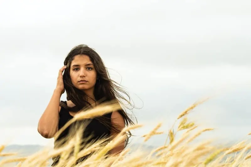 Ein trauriges Mädchen steht auf einem Weizenfeld