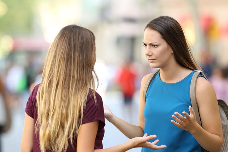 Zwei verärgerte Freunde, die draußen auf der Straße ein ernstes Gespräch führen