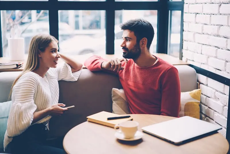 Junge Frau und Mann sprechen beim ersten Date im Café