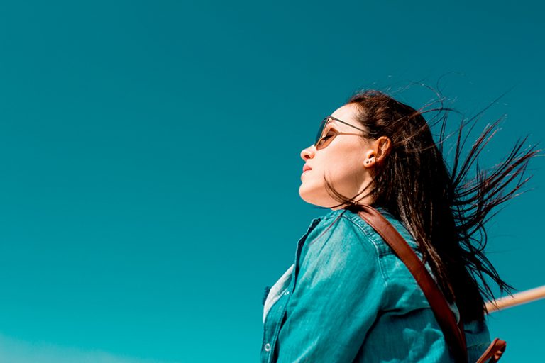 eine Frau, die an einem sonnigen Tag im Wind steht