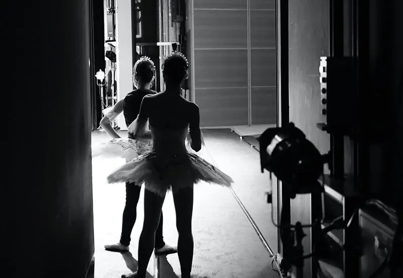 Zwei Ballerinas stehen hinter der Szene und warten auf die Aufführung
