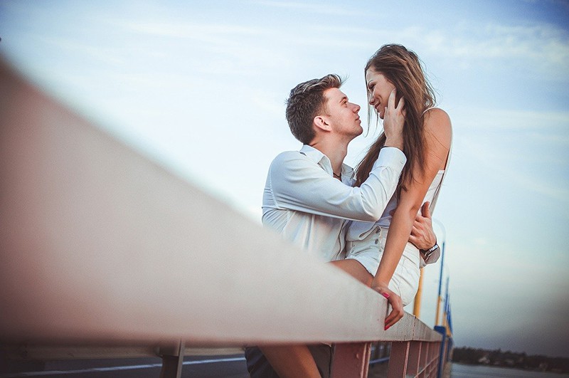 Ein Mann und eine Frau wollen sich küssen, während sie auf der Brücke stehen