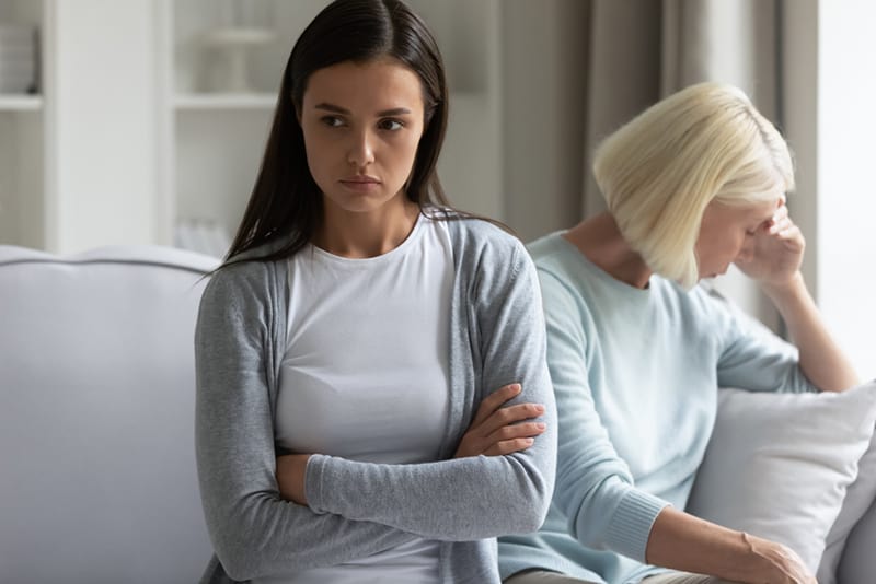 Ein junges Mädchen sitzt getrennt und vermeidet es, nach einem Kampf mit der reifen Mutter zu sprechen