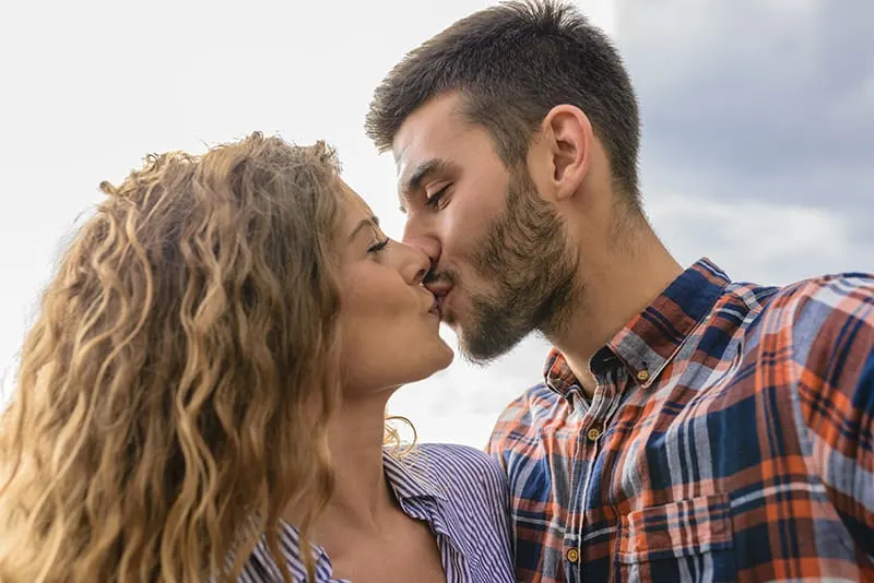 ein selbstbewusster Mann, der eine Frau bei einem Date küsst