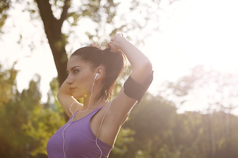 Eine Frau repariert ihre Haare und bereitet sich auf das Joggen vor