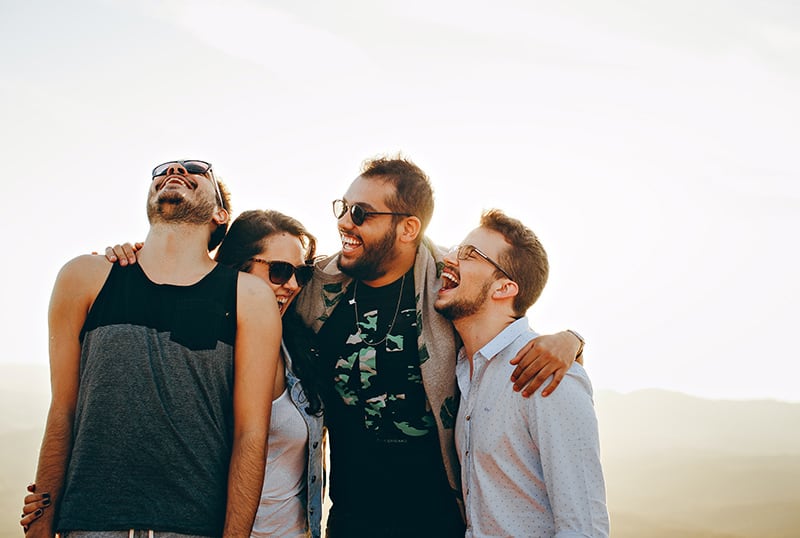 eine Gruppe lächelnder Freunde, die sich umarmen