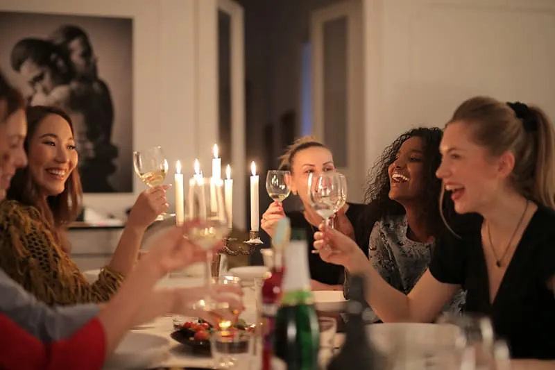 eine Gruppe von Freundinnen, die während eines Abendessens auf einer Geburtstagsfeier einen Toast trinken