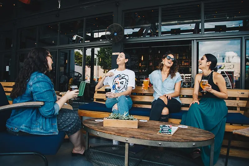 vier Freundinnen haben Spaß beim gemeinsamen Trinken in der Bar