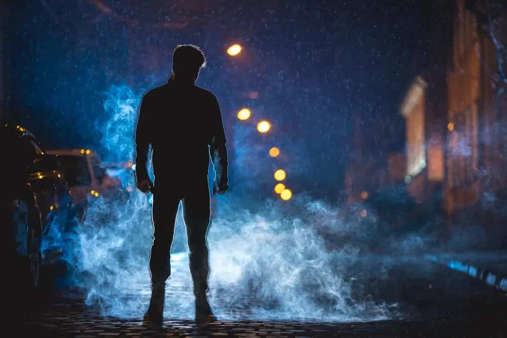Ein Mann steht im Dunkeln auf der Straße