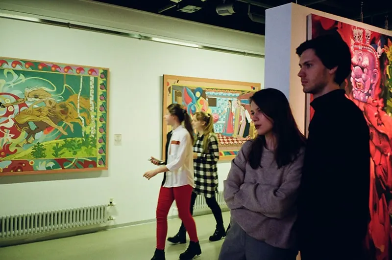Ein Mann und eine Frau schauen sich eine Kunstausstellung in der Galerie an