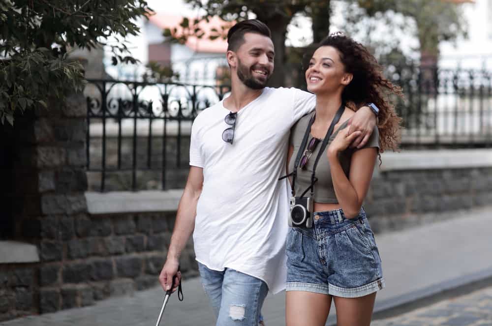 Ein lächelndes Paar in einer Umarmung geht die Straße entlang