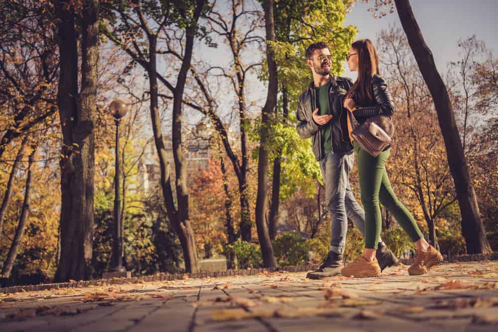 Ein liebevolles Paar geht durch den Park und sie reden