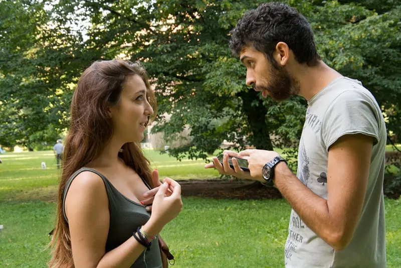 Ein zweifelhafter Mann bat seine Freundin um eine Erklärung, während er auf das Smartphone zeigte
