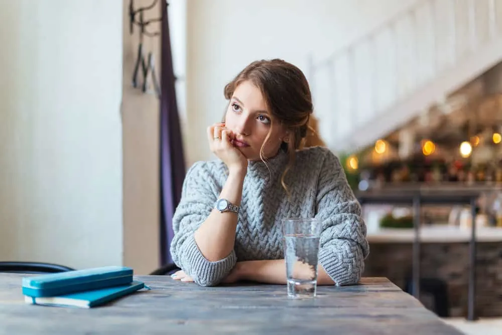 Eine Frau sitzt in einem Café und langweilt sich