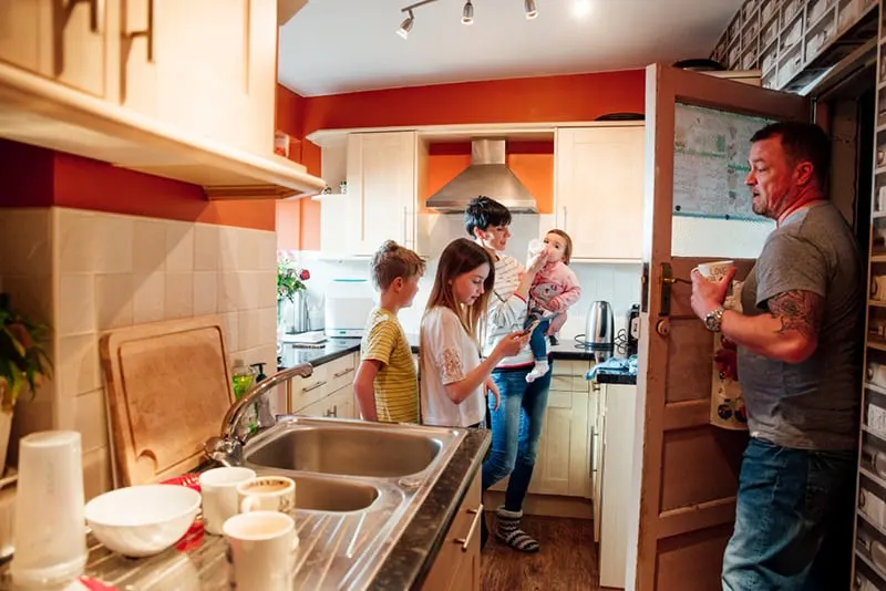 Eine ganze Familie ist in der Küche ihres Hauses beschäftigt
