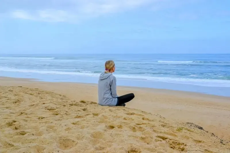 Frau sitzt am Strand