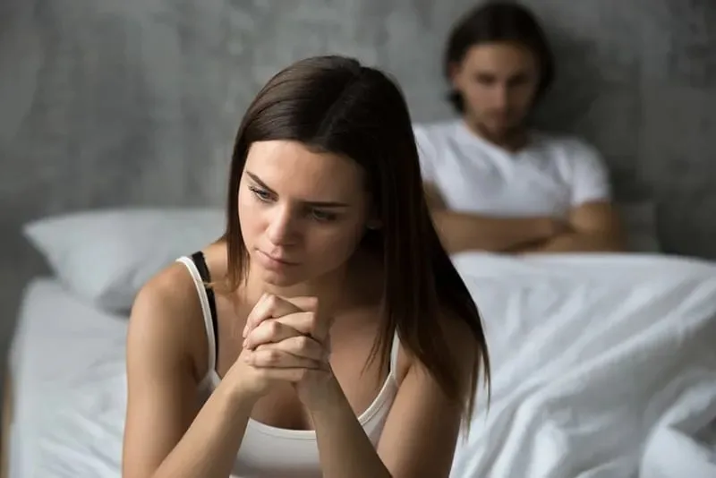 traurige Frau mit Mann im Bett