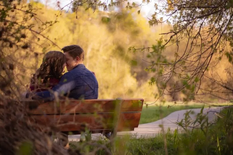 Im Park auf der Bank küsst sich ein liebendes Paar