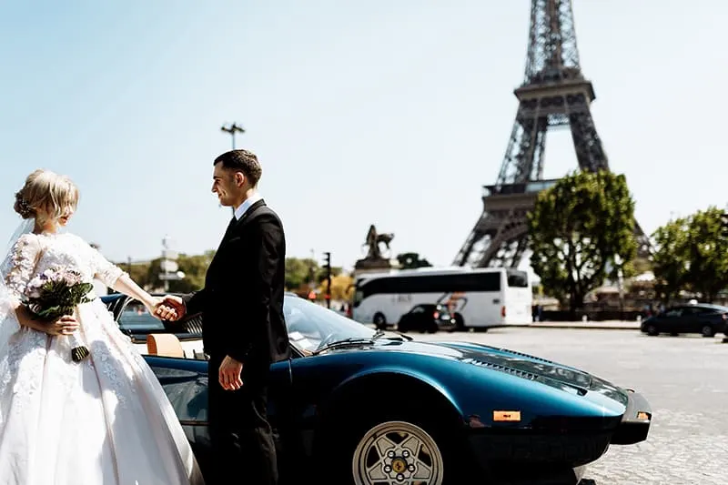 Jungvermählten in Paris in der Nähe des Autos stehen