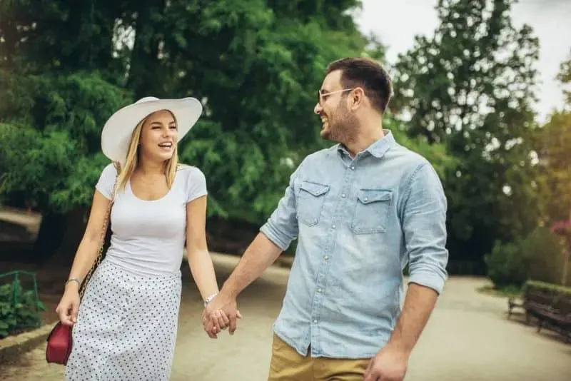 laechelndes Paar zu Fuss im Freien