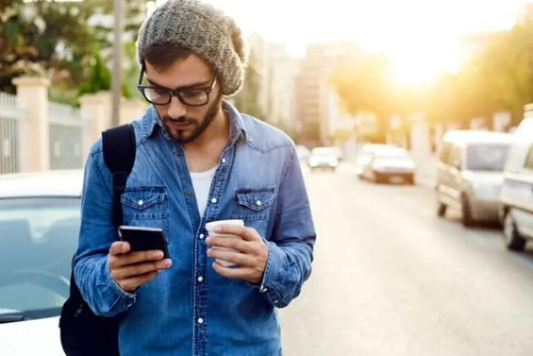 Mann schaut aufs Telefon