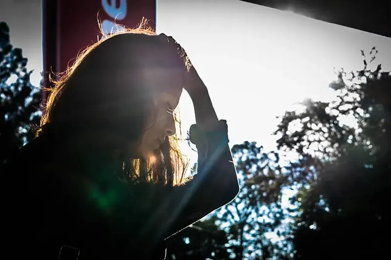 Frau haelt Hand auf Kopf