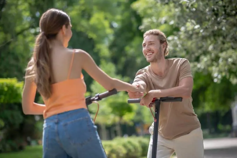 Im Park trifft ein lächelnder Mann eine Frau