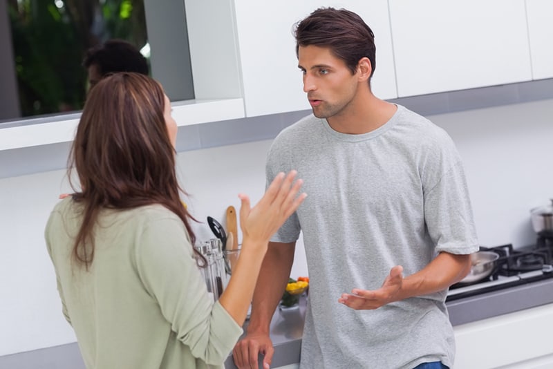 Ein Mann und eine Frau streiten sich, während sie in der Küche stehen