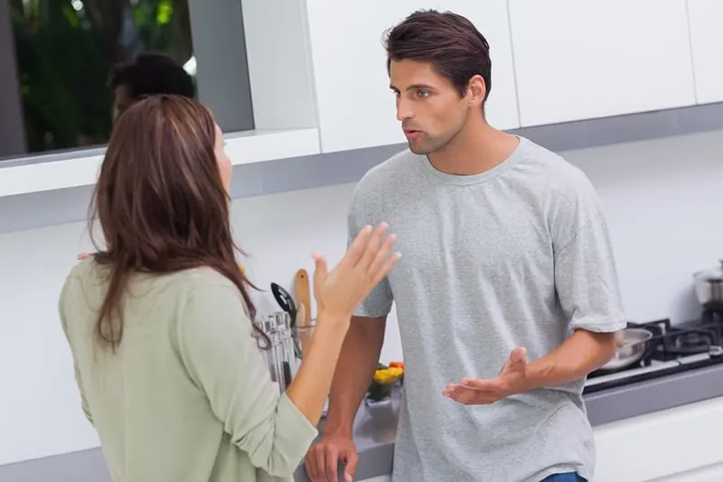 Ein Mann und eine Frau streiten sich, während sie in der Küche stehen